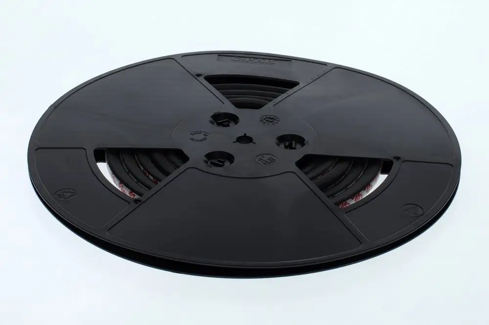 Schwarze Kunststoffspule mit mehreren Schlitzen, die einen Mittelsteg zeigt. Die Spule ist als Aufbewahrungs- oder Transporthilfe erkennbar und könnte für Bosch Produkte verwendet werden.